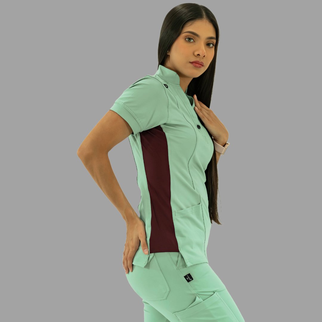 Filipina médica en verde menta y vino, pose de tres cuartos con mano en la cadera.