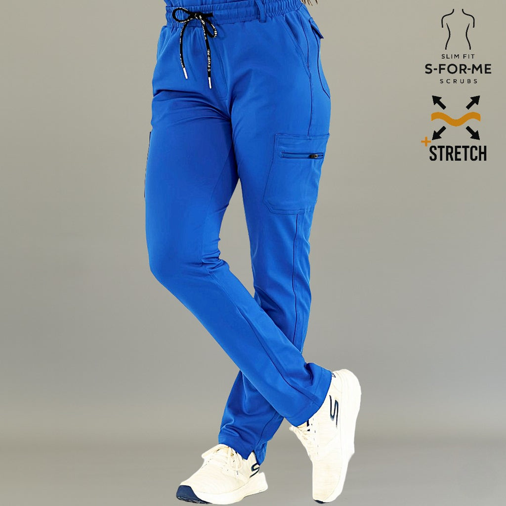 Pantalón médico 930 azul rey en vista frontal con piernas cruzadas y manos en los bolsillos.