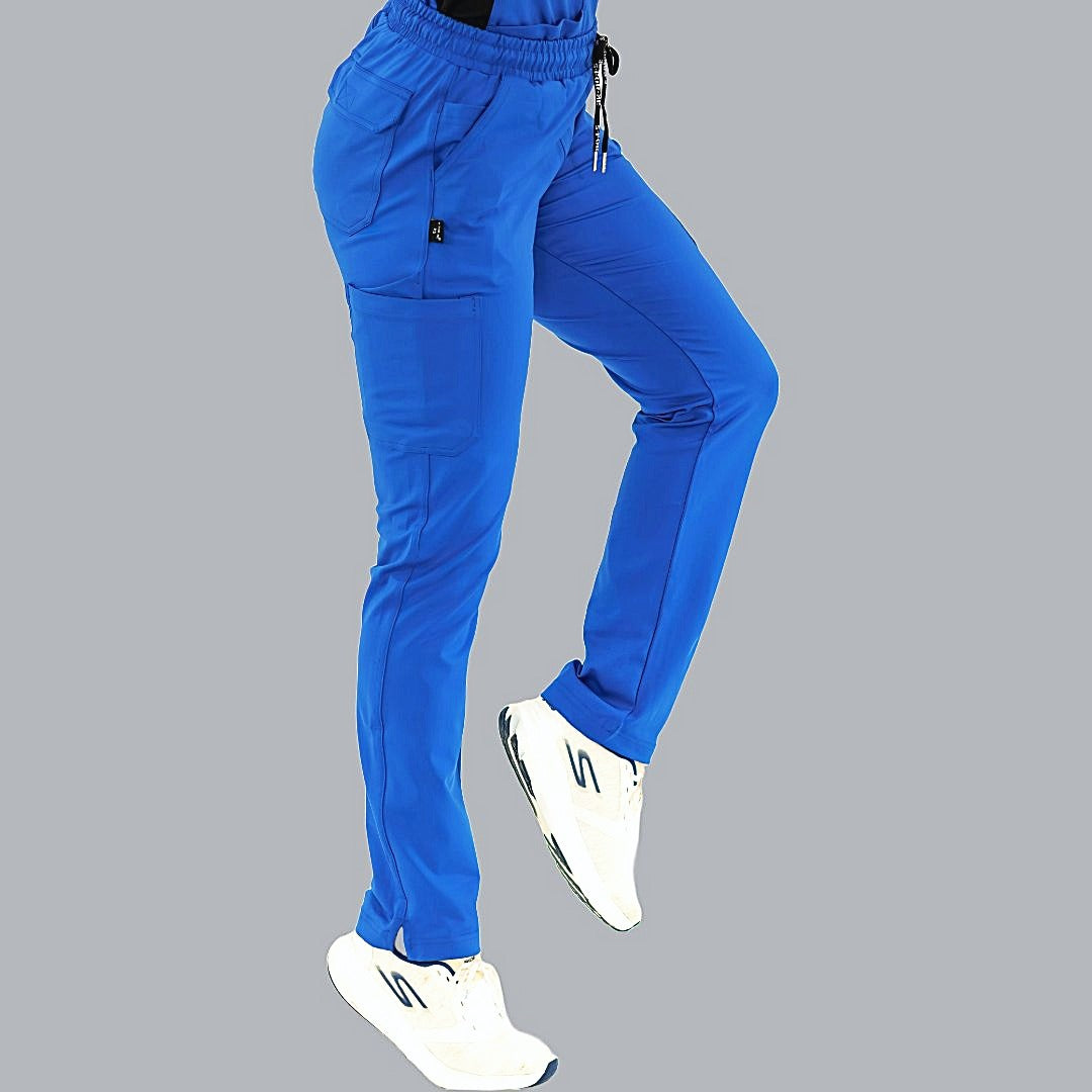 Pantalón médico 930 color azul rey en vista lateral, pierna izquierda flexionada y pie levantado.